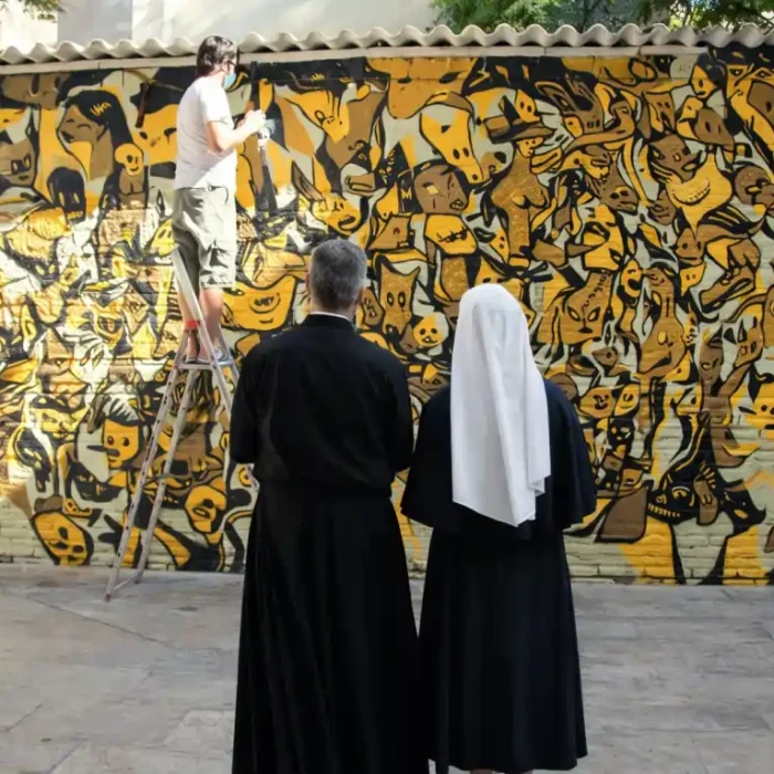 cura y una monja observando un mural graffiti en valencia