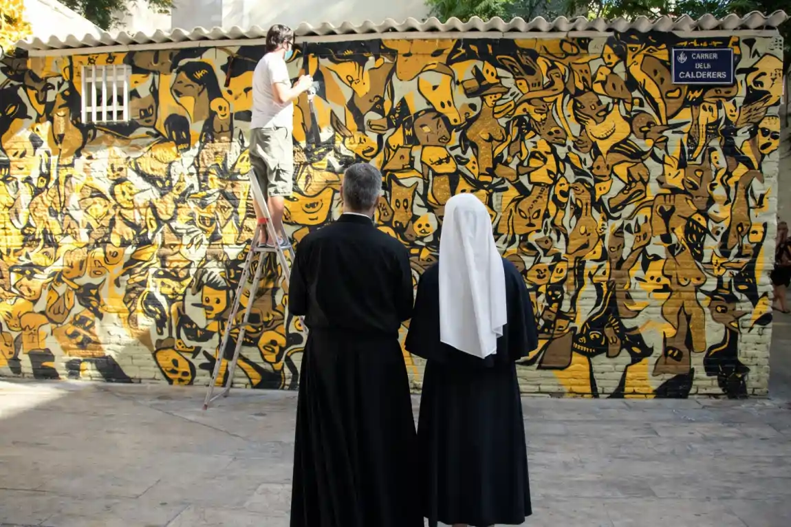 cura y una monja observando un mural graffiti en valencia